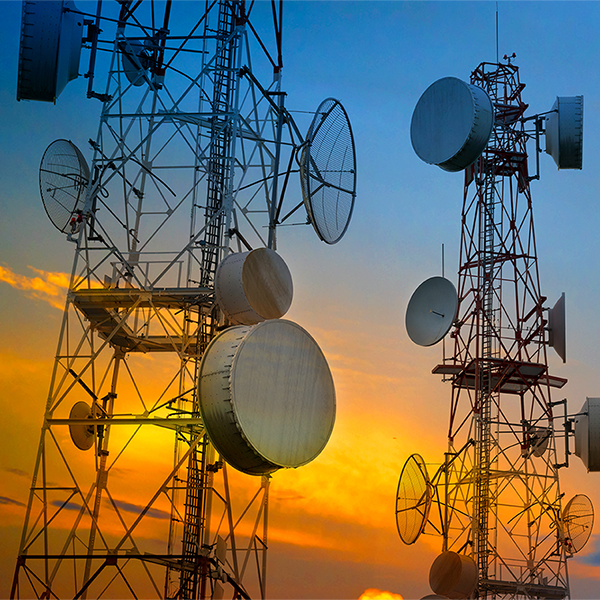 Telecommunication towers with wireless antennas on sunset sky